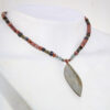 Choker en pierre de rivière et kyanite avec pendentif en forme de feuille, élégant et unique.