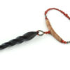 Choker design en bois exotiques & Jaspe rouge, avec pour pendentif une vrille en bois d'ébène noir, attachée par un cercle de petite perle de pyrité bronze doré scintillant, reliée à une pièce balancelle courbée en bois d'olivier crème foncé boisé, et un fil de perles rouge brique ponctués de deux de pyrite partent des deux côté de la pièce jusqu'au fermoir puzzle aimanté de forme triangulaire, avec un pendant de perles noires en fermeture