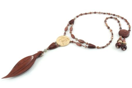 Collier Princesse en bois de Violette sculpté, avec pour pendentif une feuille élancée en bois violet foncé, un disque crème boisé, un collier de perles violet foncé avec des touches de gris et un fermoir puzzle aimanté qui se termine par un double pendant de perles