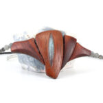 Un collier ras-de-cou qui révèle le sanctuaire du féminin en bois de Padouk avec une pierre taillée en forme oblongue au centre