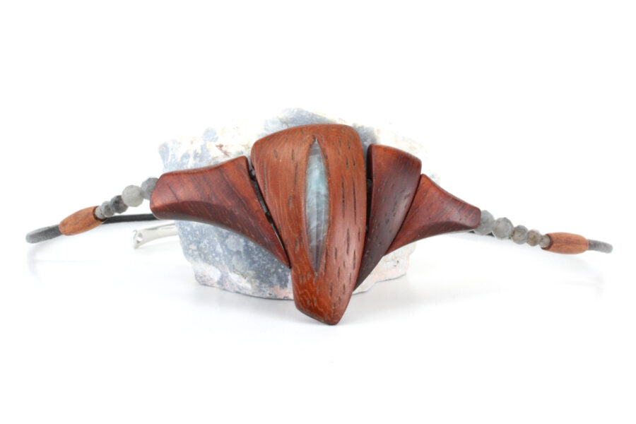 Un collier ras-de-cou qui révèle le sanctuaire du féminin en bois de Padouk avec une pierre taillée en forme oblongue au centre