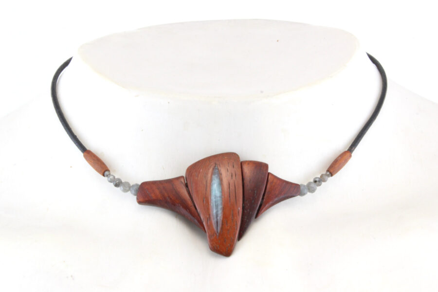 Un collier ras-de-cou qui révèle le sanctuaire du féminin en bois de Padouk avec une pierre taillée en forme oblongue au centre