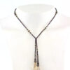 un collier lariat sensuel en perles naturelles de Bronzite et perles noires avec des touches dorées et marron qui se termine par deux cristaux de couleur ambre