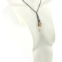 un collier lariat sensuel en perles naturelles de Bronzite et perles noires avec des touches dorées et marron qui se termine par deux cristaux de couleur ambre