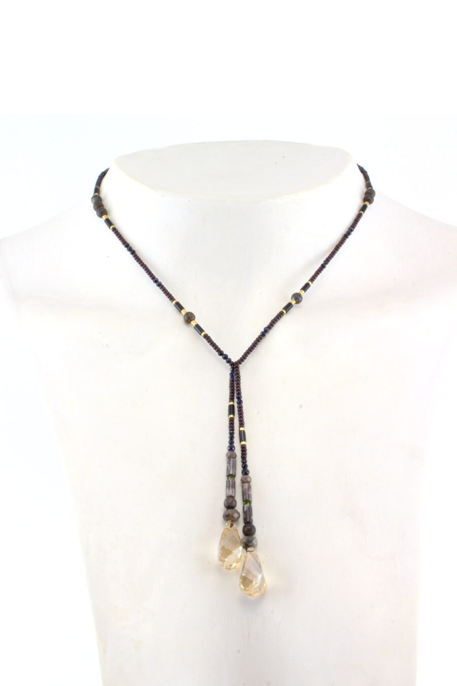 un collier lariat sensuel en perles naturelles de Bronzite et perles noires avec des touches dorées et marron qui se termine par deux cristaux de couleur ambre