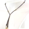 un collier lariat sensuel en perles naturelles de Bronzite et perles noires avec des touches dorées et marron qui se termine par deux cristaux de couleur ambre
