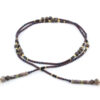 un collier lariat sensuel en perles naturelles de Bronzite et perles noires avec des touches dorées et marron qui se termine par deux cristaux de couleur ambre