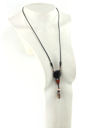 Collier totem en bois exotiques et Jaspe Picasso, avec en pendentif un disque noir ébène, une petite pièce en bois bombée orange foncé, une suite de perles et une pierre sculptée en forme d'olive vert tacheté d'orange. Cordon de cuir noir relié aux pendant avec deux pièces de bois sculpté en forme d'olive