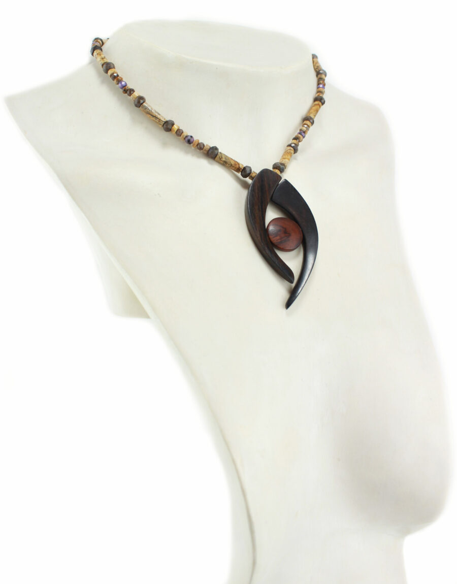 Collier choker en bois précieux et perles naturelles , dont la forme rappelle une pince noire en ébène qui tient en son centre une pleine lune en cocobolo