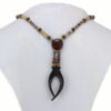 Collier choker en bois précieux et perles naturelles , dont la forme rappelle une pince noire en ébène qui tient en son centre une pleine lune en cocobolo