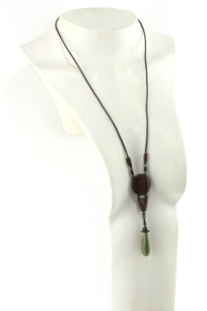 Sautoir en bois sculpté & perles naturelles : cordon en cuir avec pendant ethnique, un cercle sculpté en bois marron relié par des perles noires à une pièce en bois bombée marron, reliée à une suite de perles qui se terminent par une pierre verte d'Unakite